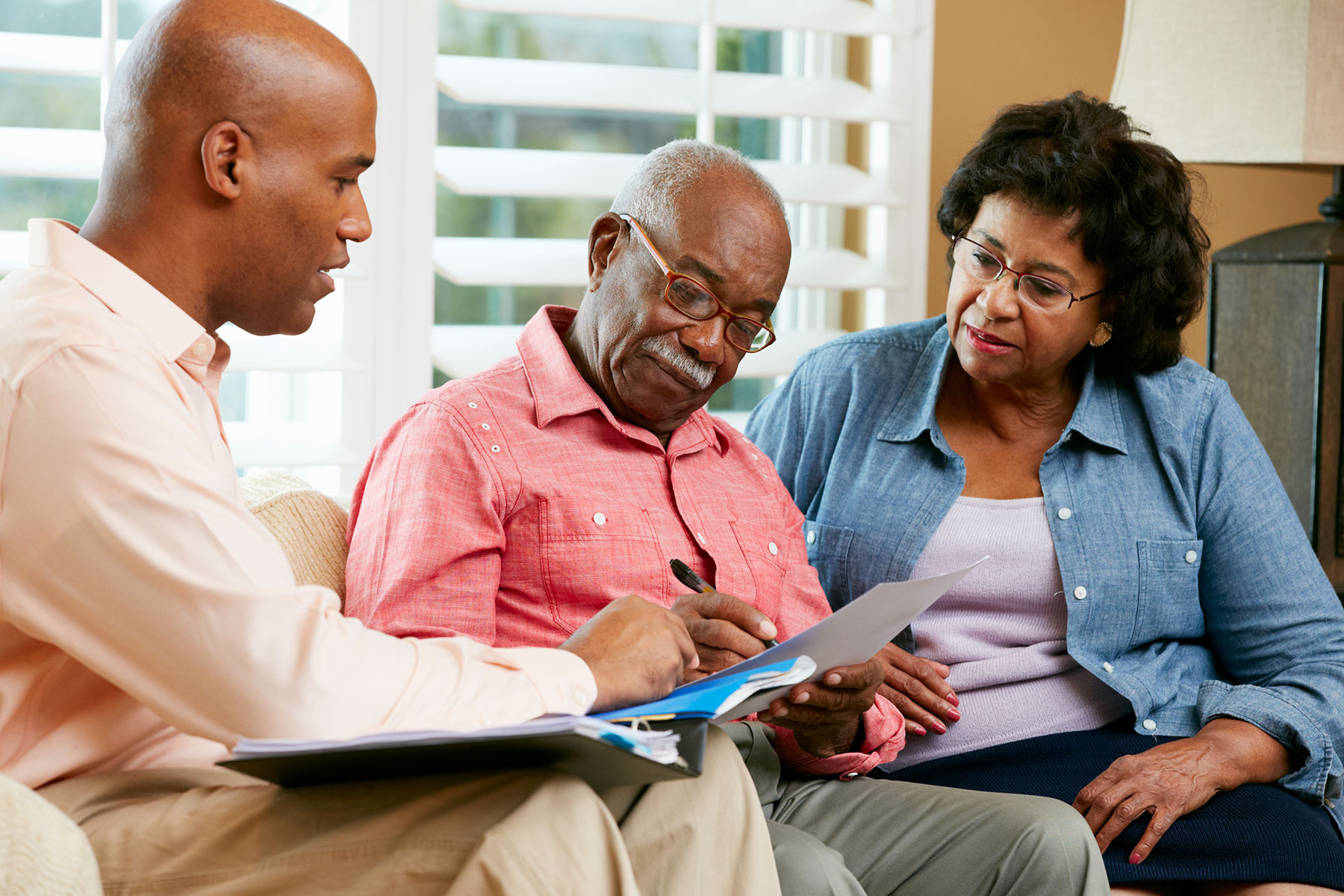 Senior African American couple looking at papers on the couch | Using A Reverse Mortgage To Settle A Divorce