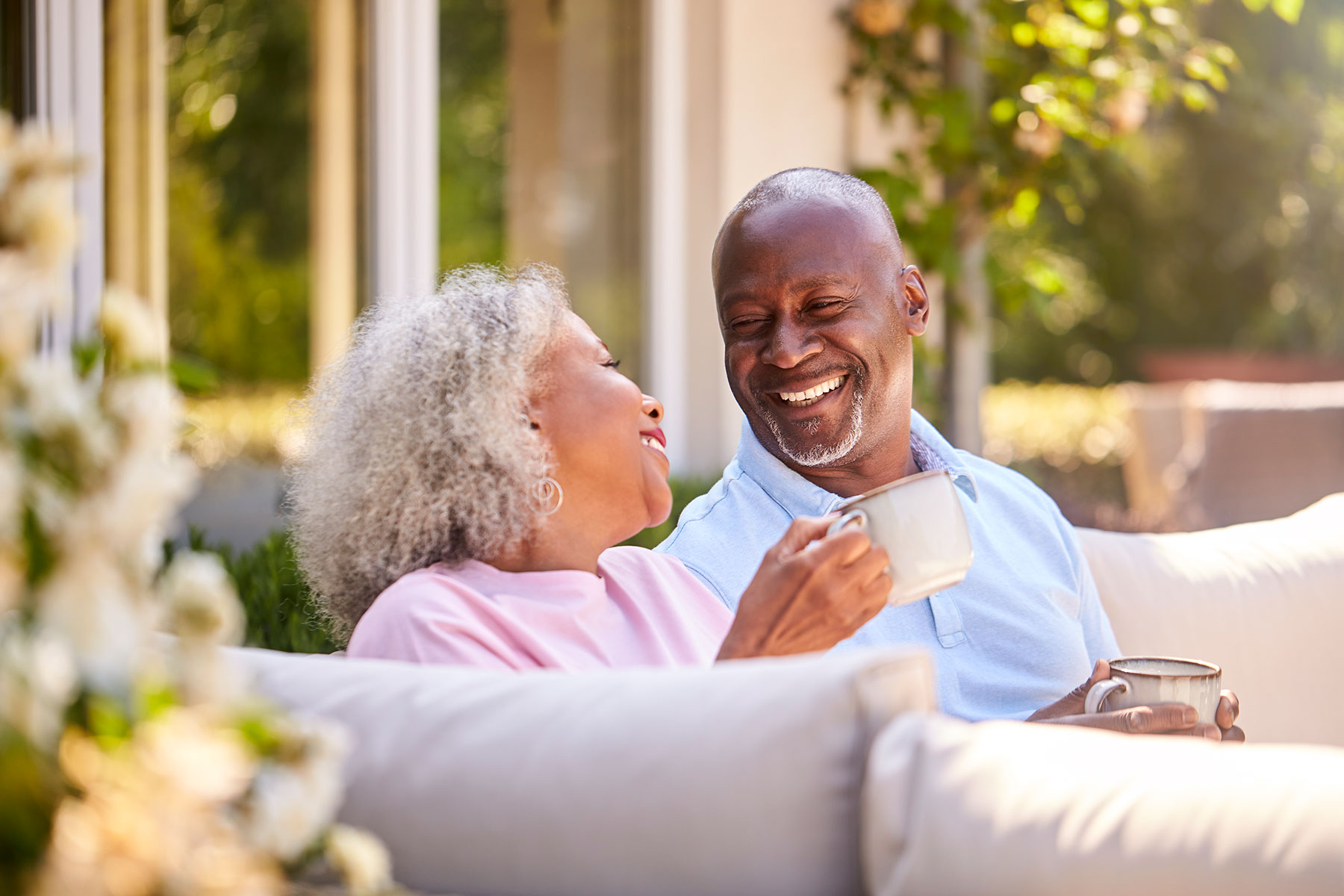 senior African American couple drinking coffee on the couch | Reverse Mortgage Life Expectancy Set-Asides